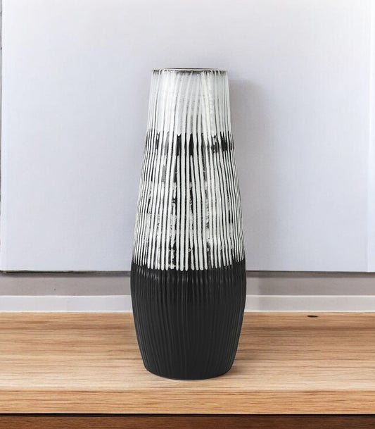 Decorative vase with black and white pattern on a wooden surface