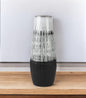 Decorative vase with black and white pattern on a wooden surface