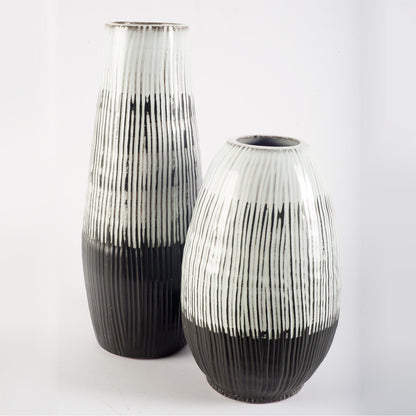 Two black and white striped vases on a light gray background