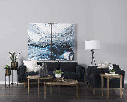 Modern living room with dark blue sofa, wooden coffee table, and abstract art on the wall.
