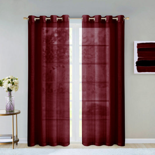 Pair of red plaid curtains with grommets on a window, with a small table and flowers in the background.