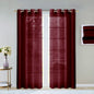 Pair of red plaid curtains with grommets on a window, with a small table and flowers in the background.