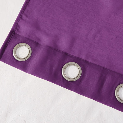Close-up of a purple curtain with metallic eyelets on a white background