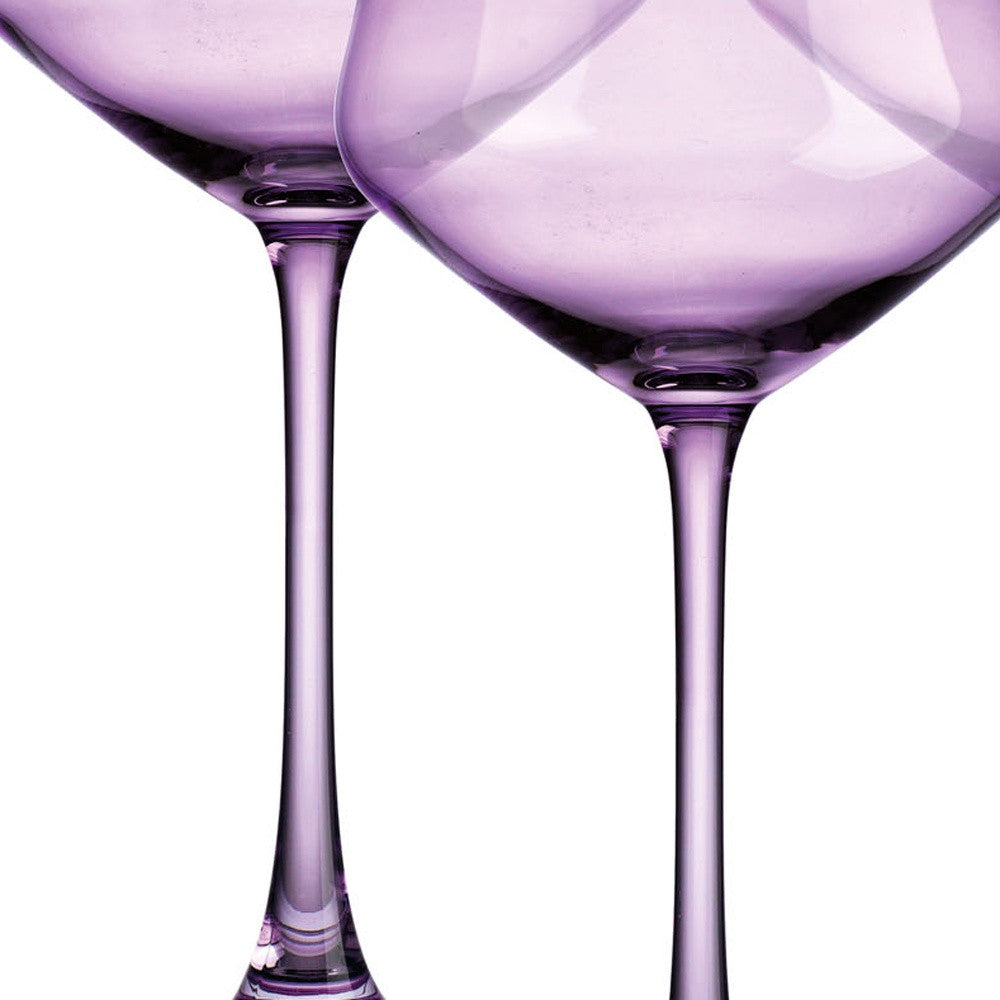 Two purple wine glasses on a white background