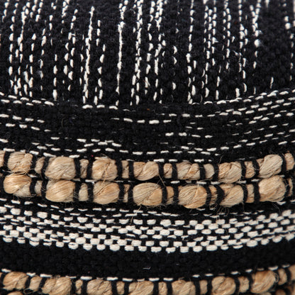 Close-up of a woven black and white hat with natural fiber trim.