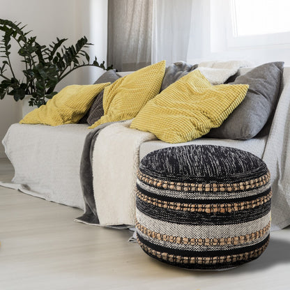 Decorative ottoman in front of a sofa with yellow and gray pillows.