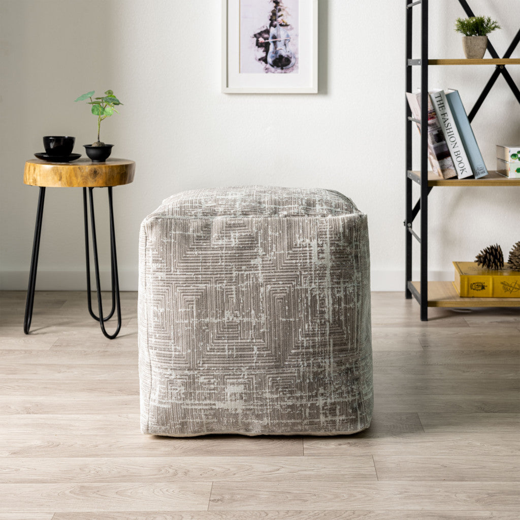 Textured ottoman in a room with a side table and bookshelf.