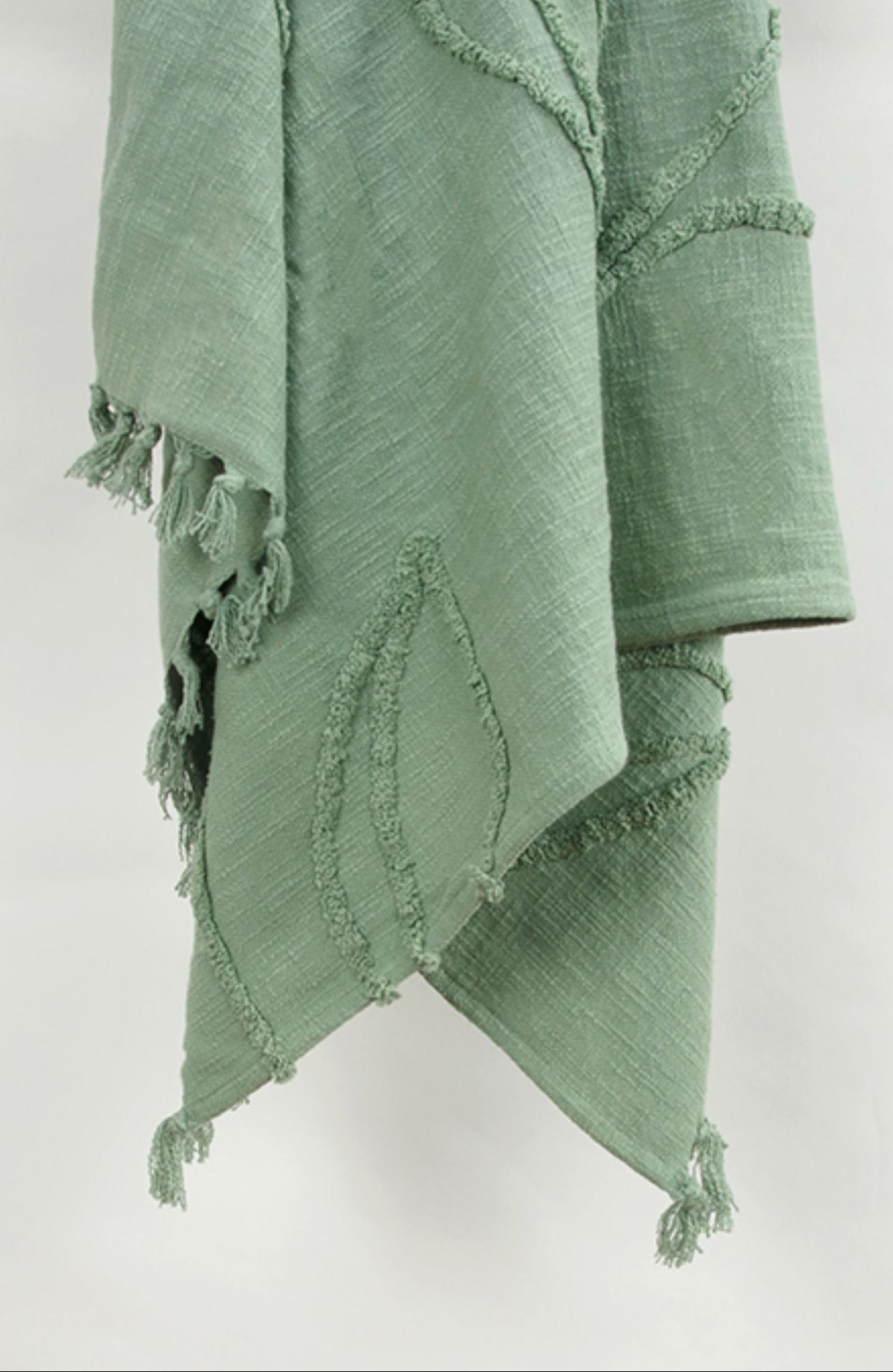 Green textured blanket with frayed edges on a white background