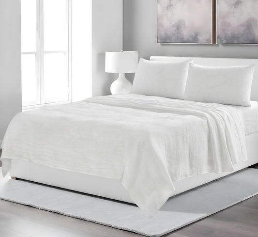 White bedding set on a bed in a modern bedroom with abstract art on the wall.