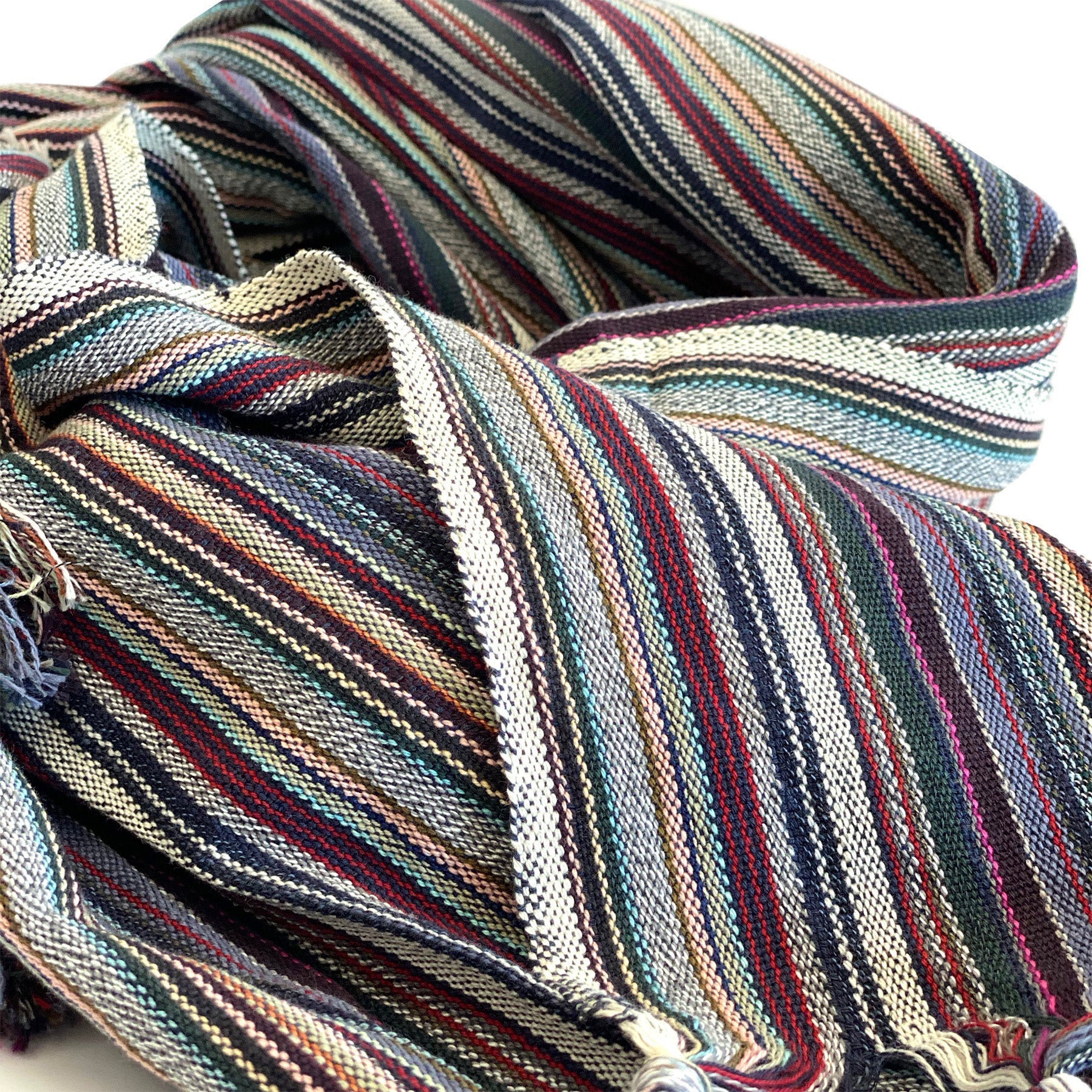 Multicolored striped fabric with tassels on a white background