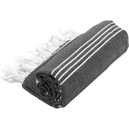 Folded black and white striped towel with fringes on a white background