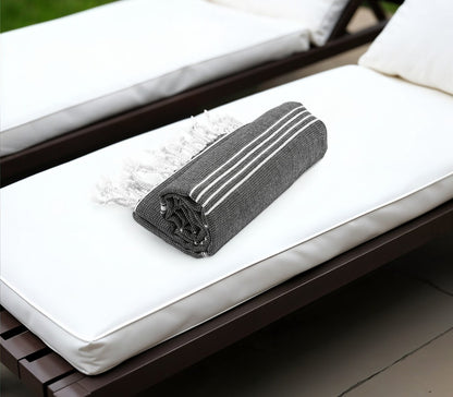 Black textured rectangular object on a white cushioned chair
