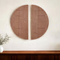 Two circular wooden wall art pieces with wavy line patterns on a white wall.