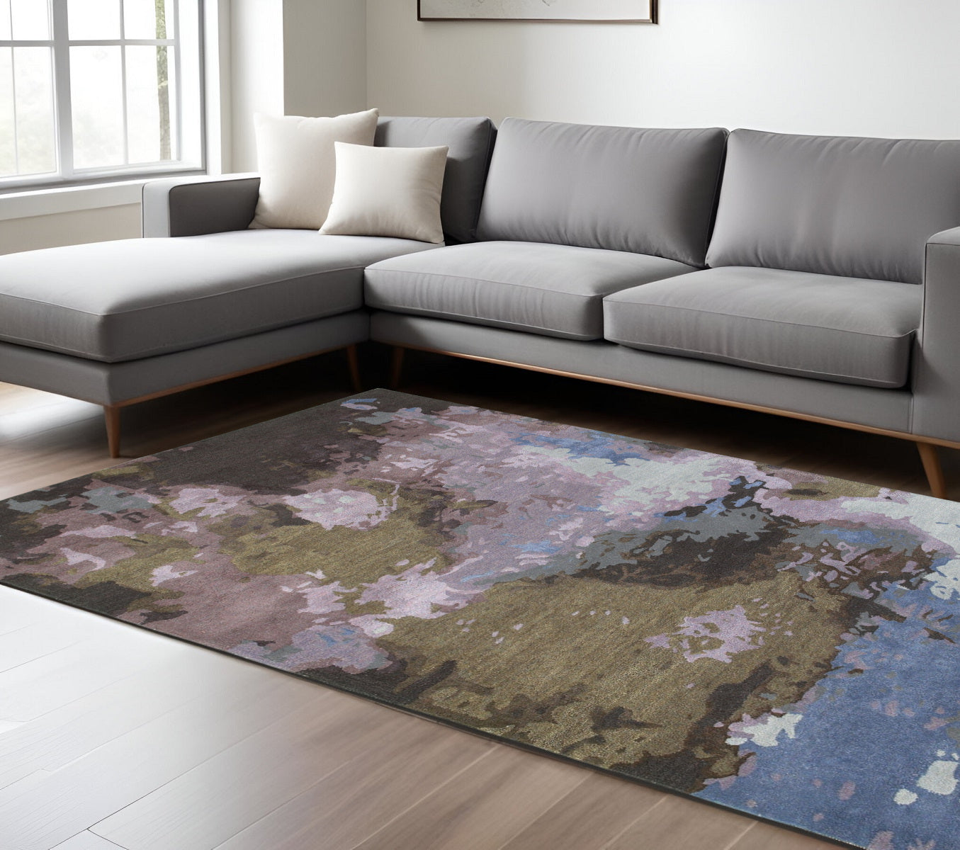 Gray sectional sofa in a living room with a floral-patterned rug.