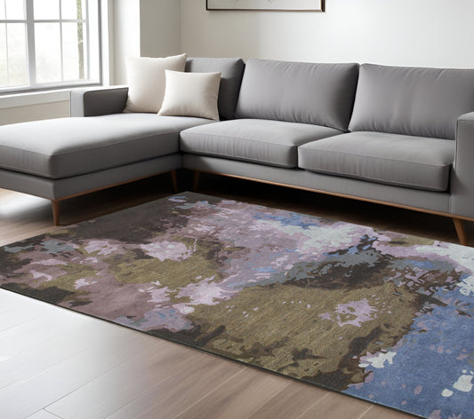 Gray sectional sofa in a living room with a floral-patterned rug.