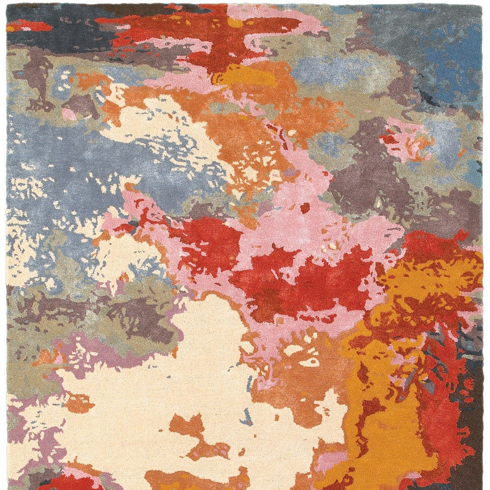 Multicolored abstract patterned rug with a mix of red, blue, orange, and beige.