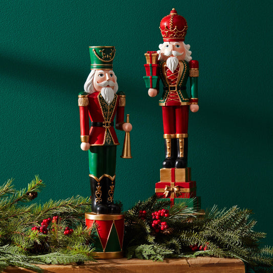 Two decorative nutcrackers with festive attire on a green background