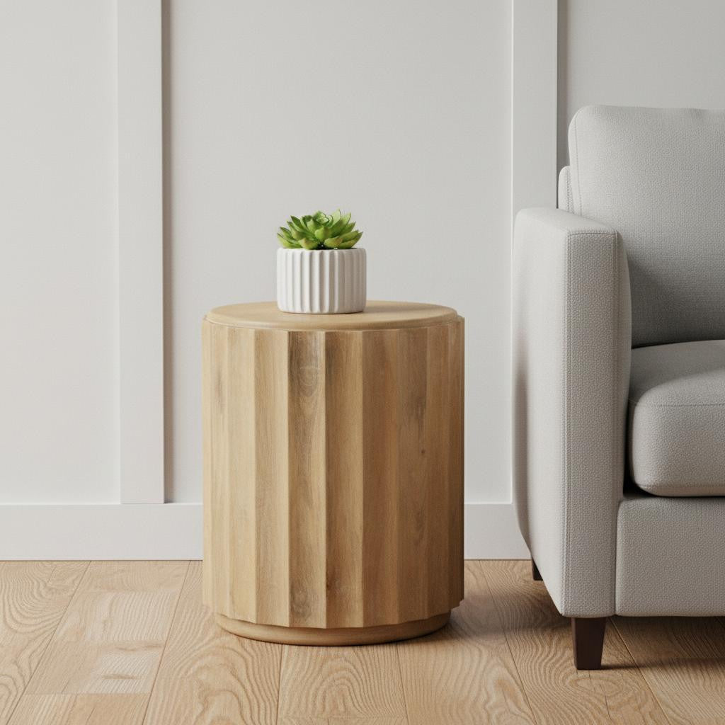 Wooden side table with a plant next to a gray sofa in a room.