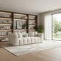 Modern living room with a white sofa, bookshelves, and large windows.